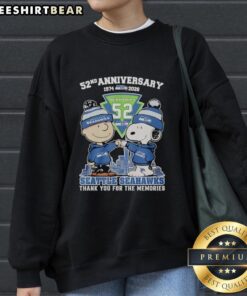 Alt Text: Stylish Seattle Seahawks outfit featuring a Snoopy and Charlie Brown sweatshirt celebrating their 52nd anniversary, 1974-2026.