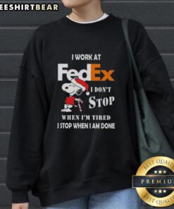 Cozy Christmas sweatshirt featuring Snoopy with the quote 'I don't stop when I'm tired, I stop when I'm done' for FedEx workers.