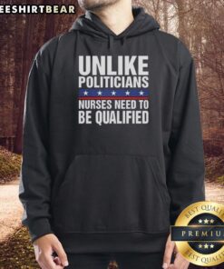 Satirical hoodie design featuring 'Pretty Unlike Politicians' with a nurse illustration, emphasizing the need for qualified nurses.