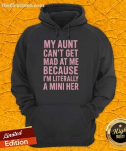 A young girl in a hoodie that says 'My Aunt Can't Get Mad At Me Because I'm Literally A Mini Her' smiling joyfully.