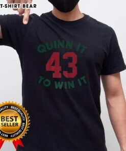 Top Quinn Hughes Minnesota Wild NHL 'Quinn It To Win It' Number 43 T-Shirt displayed on a hanger, showcasing team colors.