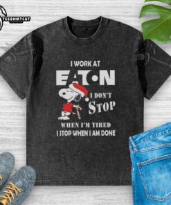 Alt Text: Snoopy graphic on a Christmas T-shirt: 'I Work At Eaton Corporation, I Don't Stop When I'm Tired' design.