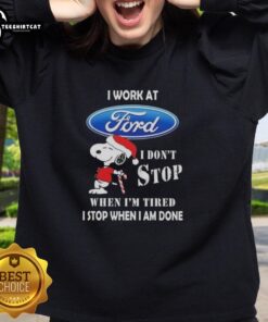 Cozy Christmas sweatshirt featuring Snoopy and 'I Work At Ford Motor, I Dont Stop When Im Tired' slogan.