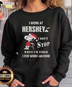 Cozy Christmas sweatshirt featuring Snoopy with 'I Work At Hershey, I Dont Stop When Im Tired' slogan.