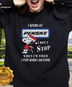 Cozy Christmas sweatshirt featuring Snoopy with 'I Work At Penske Corporation' and motivational quote for festive style.