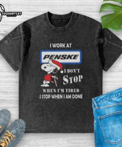 Alt Text: Snoopy graphic t-shirt featuring 'I Work at Penske Corporation' and motivational quote for Christmas.