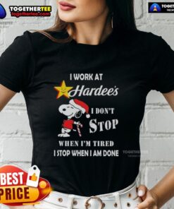 Christmas ladies tee featuring Snoopy with 'I work at Hardee's' slogan, showcasing determination and holiday spirit.