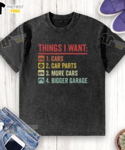 Person wearing a 'Top Things I Want: Car Parts, More Cars, Bigger Garage' t-shirt while standing in a garage.