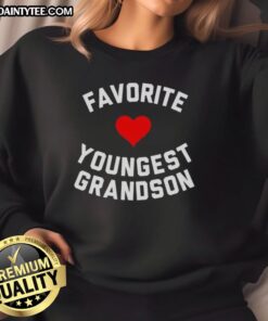 Young boy wearing an Awesome Favorite Youngest Grandson heart sweatshirt, smiling joyfully outdoors.