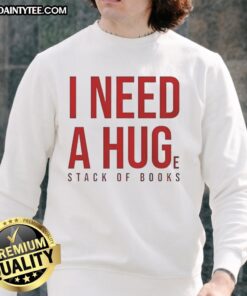 Cozy 'Awesome I Need A Huge Stack Of Books' sweatshirt displayed on a wooden table with scattered books around it.