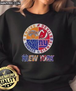 Alt Text: Awesome New York City sports sweatshirt featuring Knicks, Devils, Giants, and Yankees logos in a stylish design.