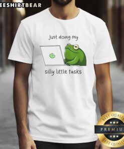 Alt Text: Cute frog illustration on a t-shirt with the phrase 'Just Doing My Silly Little Tasks' in playful font.