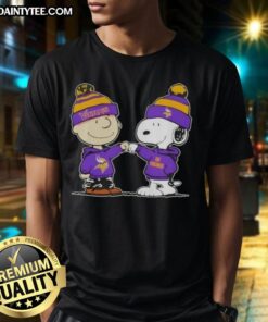 Charlie Brown and Snoopy fist bump on Minnesota Vikings football T-shirt, perfect for fans of Peanuts and NFL.