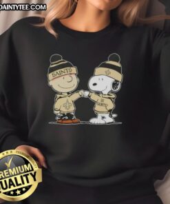 Alt Text: Cute Peanuts Charlie Brown fist bump with Snoopy on New Orleans Saints football sweatshirt design.