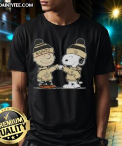 Charlie Brown and Snoopy fist bump on New Orleans Saints football T-shirt, perfect for fans of Peanuts and NFL.