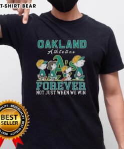 Alt Text: Cute Snoopy and Charlie Brown Oakland Athletics baseball t-shirt showcasing 'Forever Not Just When We Win' slogan.