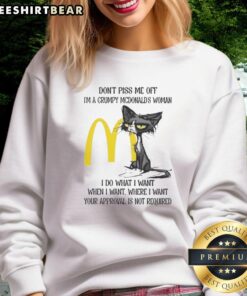 Funny tired cat with grumpy expression wearing a McDonald's sweatshirt saying 'I do what I want'.