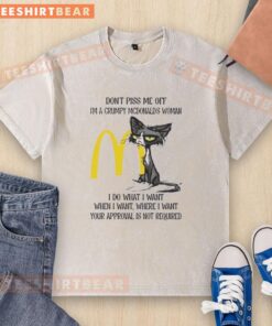 Alt Text: Grumpy cat wearing a I'm a Grumpy McDonald's Woman t-shirt, looking tired and funny, perfect for cat lovers.