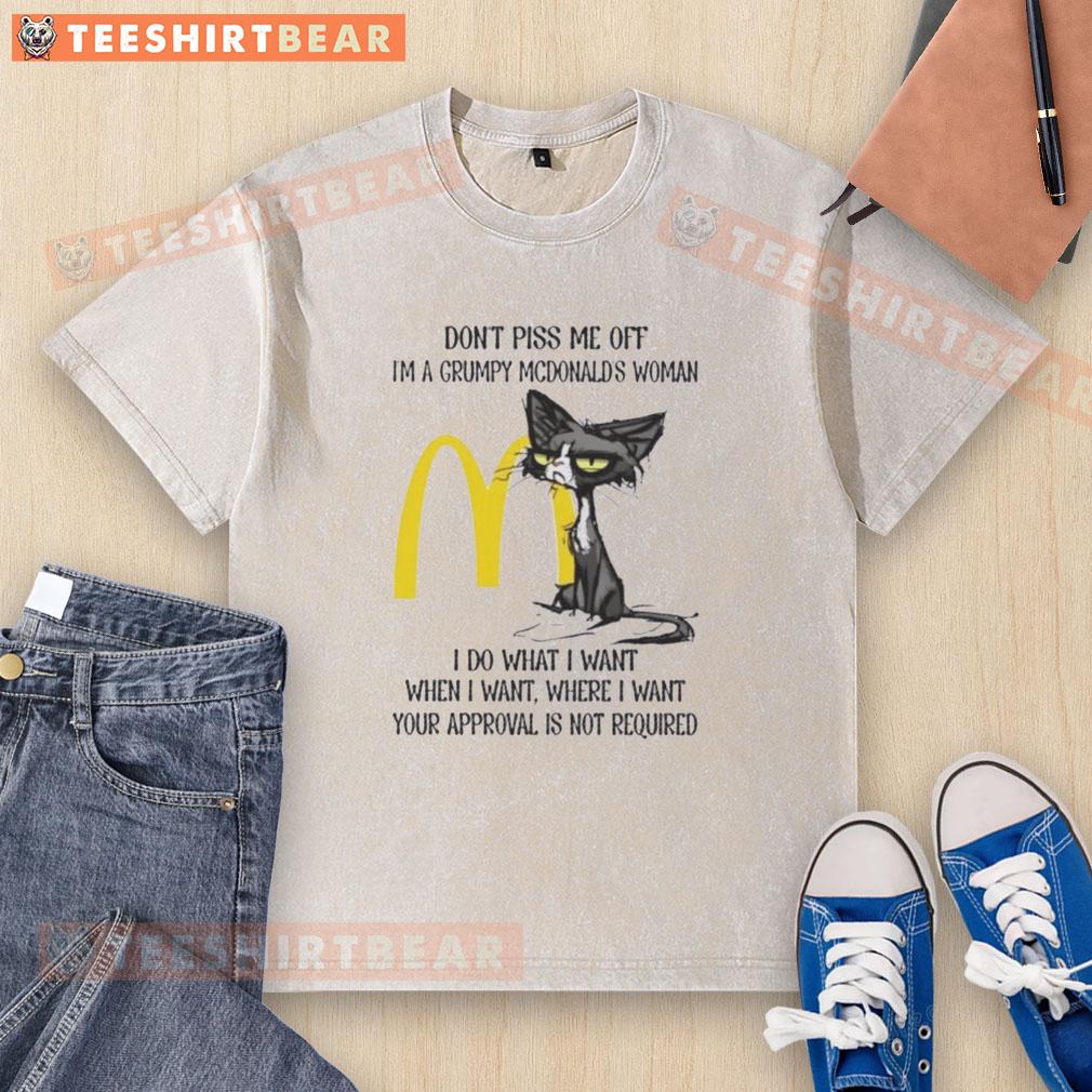 funny-tired-cat-dont-piss-me-off-im-a-grumpy-mcdonalds-woman-i-do-what-i-want-washed-t-shirt Alt Text: Grumpy cat wearing a I'm a Grumpy McDonald's Woman t-shirt, looking tired and funny, perfect for cat lovers.