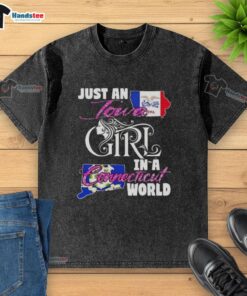 Good Just An Iowa Girl In A Connecticut World washed t-shirt displayed on a rustic wooden background.