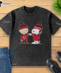 Charlie Brown and Snoopy fist bump on a washed T-shirt featuring Atlanta Falcons logo, celebrating good vibes and football.