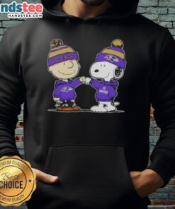 Charlie Brown and Snoopy fist bump in a Baltimore Ravens football hoodie, celebrating friendship and team spirit.