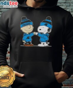 Alt Text: Charlie Brown and Snoopy fist bump in Carolina Panthers football hoodie, celebrating friendship and team spirit.