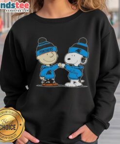 Charlie Brown and Snoopy fist bump on a Carolina Panthers football sweatshirt, showcasing Good Peanuts design.