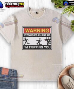 Funny 'If Zombies Chase Us, I'm Tripping You' washed t-shirt design featuring humorous zombie survival quote.