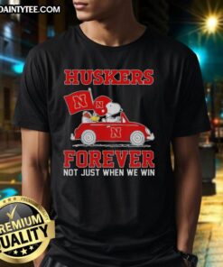 Hot Snoopy and Woodstock driving a car on a Nebraska Huskers T-shirt, perfect for fans of both Peanuts and college sports.