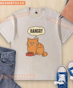 Adorable cat looking hangry while wearing a washed t-shirt, showcasing its playful personality and cute expression.