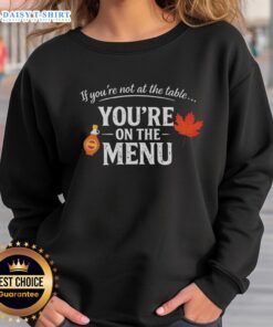 Nice If You're Not At The Table You're On The Menu sweatshirt, featuring bold text design on a cozy garment.