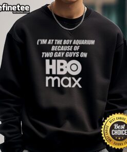 Person wearing a 'Nice I'm at the Boy Aquarium' HBO Max sweatshirt, enjoying time at the aquarium with two friends.