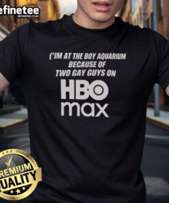 Man wearing 'Nice I'M At The Boy Aquarium Because Of Two Guys' HBO Max T-shirt, standing in front of an aquarium.