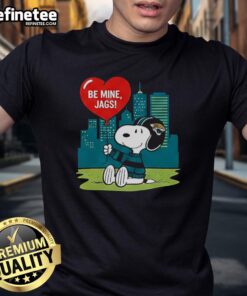 Alt Text: Jacksonville Jaguars X Snoopy cartoon Valentine 2026 T-shirt featuring fun graphics and vibrant colors for fans.