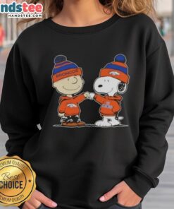 Charlie Brown and Snoopy fist bump in Denver Broncos sweatshirt, celebrating friendship and football spirit.