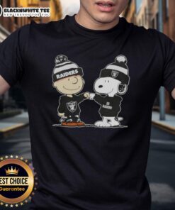 Nice Peanuts Charlie Brown fist bump with Snoopy on a Las Vegas Raiders football T-shirt for fans and collectors.