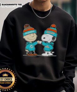 Charlie Brown and Snoopy fist bump on a Miami Dolphins football sweatshirt featuring Nice Peanuts design.