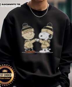 Charlie Brown and Snoopy fist bump in New Orleans Saints football sweatshirt, celebrating friendship and team spirit.