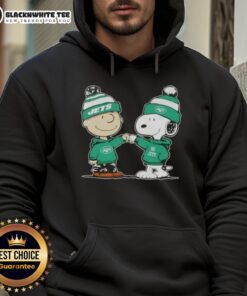 Charlie Brown and Snoopy fist bump in a New York Jets football hoodie, showcasing a fun Nice Peanuts design.
