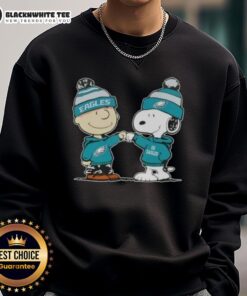 Alt Text: Charlie Brown and Snoopy fist bump on a Philadelphia Eagles football sweatshirt featuring Nice Peanuts design.