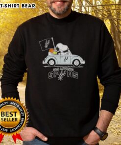 Alt Text: Snoopy driving a car in a San Antonio Spurs basketball sweatshirt, showcasing a fun sports-themed design.