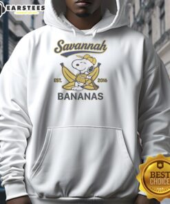 Snoopy lying on a banana, wearing a Savannah Bananas hoodie, showcasing a fun and playful design for fans.