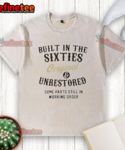 Official Built In The Sixties Original Unrestored Washed T-Shirt displayed on a wooden table, showcasing vintage style.