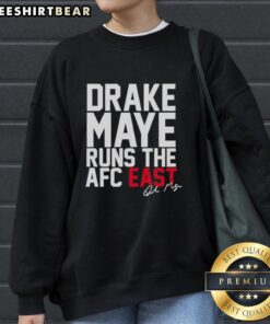Drake Maye runs the AFC East in a New England Patriots signature sweatshirt, showcasing team pride and athletic style.