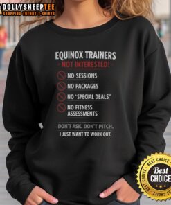 Alt Text: Official Equinox Trainers Not Interested, I Just Want to Work Out sweatshirt in a stylish gym setting.