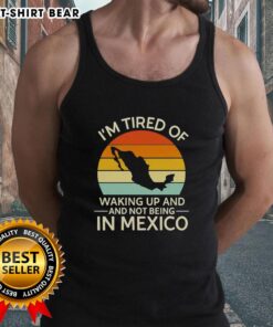 Retro tank top featuring 'I'm Tired of Waking Up and Not Being in Mexico' design against a vibrant sunset backdrop.