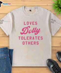Alt Text: Official Loves Dolly Tolerates Others washed t-shirt featuring a fun graphic design on a casual, stylish shirt.