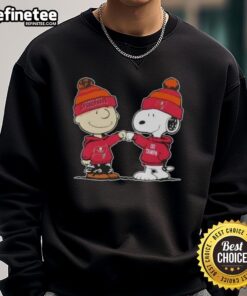 Alt Text: Official Peanuts Charlie Brown fist bump with Snoopy on Tampa Bay Buccaneers football sweatshirt design.