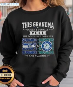 Grandma wearing a Seattle Seahawks and Mariners sweatshirt, excitedly cheering at a game, showcasing team spirit.